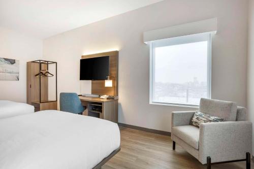 纽瓦克Comfort Inn & Suites Newark Liberty International Airport的配有一张床、一张书桌和一扇窗户的酒店客房