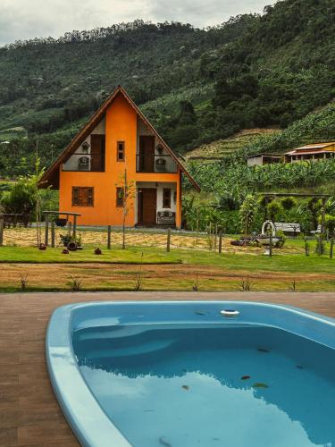 上大瓦尔任Chalé Casa em Vargem Alta的房屋前有游泳池的房子