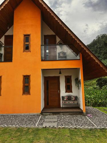 上大瓦尔任Chalé Casa em Vargem Alta的橙色和白色的房子设有阳台