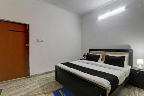 勒克瑙OYO Flagship Dripp Stay Inn的一间卧室设有一张大床和一扇红色的门