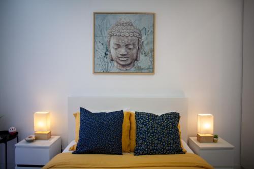 阿尔马达Just4u Apartment的一间卧室配有一张带两盏灯和一尊雕像的床。