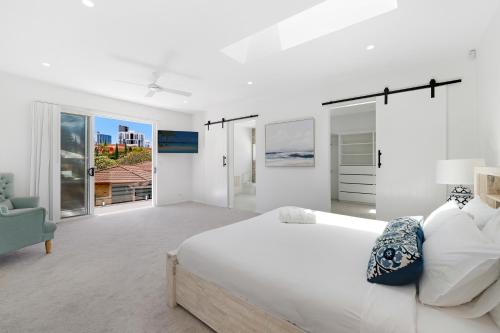 黄金海岸5BR Mermaid Waters Luxury Home的白色卧室设有一张大床和一张沙发