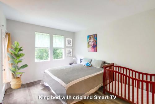 纳欣诺市Entire Private 3-Bedroom Home with Garage, AC near San Diego Gaslamp in Gated Community, 10 guests maximum的一间卧室配有一张带婴儿床的床和智能电视。