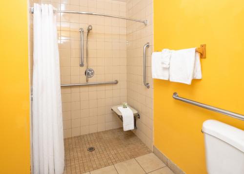 福尔布鲁克Rodeway Inn Fallbrook Downtown的带淋浴、卫生间和毛巾的浴室