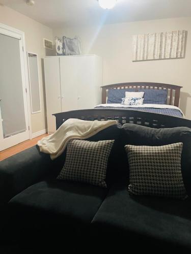 哈利法克斯RoseT的一间卧室配有两张床和一张带枕头的沙发。