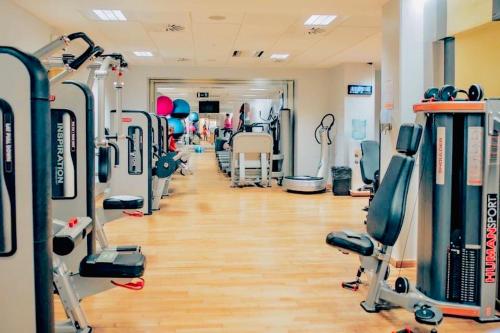 直布罗陀Lovely & Cosy Deluxe Home in Gibraltar的健身房拥有许多跑步机和机器
