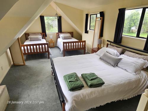 WhakatahuriCountry Cottage Rotorua的一间卧室配有两张床和绿毛巾。