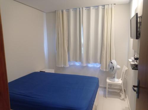 加拉尼温斯Casa de Esquina Nova的一间卧室设有蓝色的床和窗户。