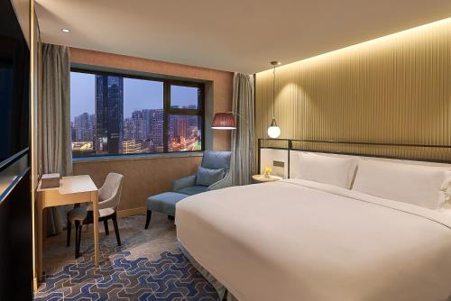 沈阳沈阳威斯汀酒店的配有一张床、一张书桌和一扇窗户的酒店客房