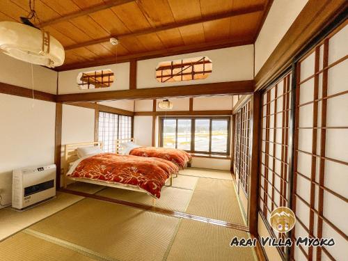 妙高Arai Villa Myoko的一间卧室设有两张床和大窗户