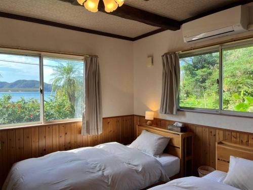 奄美Villa AdanRose Amami - Vacation STAY 06112v的带2扇窗户的客房内的2张床