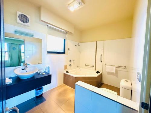 巴拉腊特城市美景康福特茵酒店及套房的带浴缸、水槽和浴缸的浴室