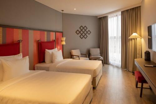 潘切M Continental by Mandala Mui Ne的酒店客房设有两张床和电视。