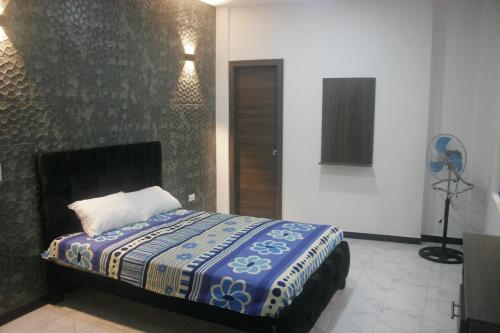圣多明各德洛斯科罗拉多斯Casa cerca del Terminal de SANTO DOMINGO的一间卧室配有一张带蓝白色毯子的床