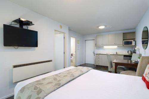 纳尔逊切尔西公园汽车旅馆 的卧室配有一张床铺,墙上配有电视