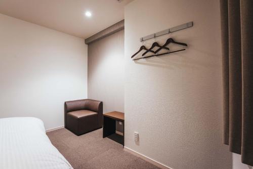 佐贺市TAPSTAY HOTEL - Vacation STAY 35240v的配有一张床和一把椅子的酒店客房
