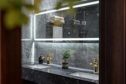 北京梦菲酒店(北京世贸天阶国贸店)的浴室镜子,配有两个盥洗盆和淋浴