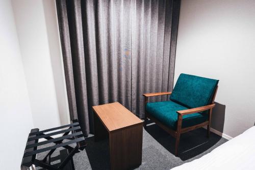 佐贺市TAPSTAY HOTEL - Vacation STAY 35241v的配有绿色椅子和桌子的房间