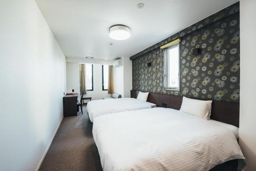 佐贺市TAPSTAY HOTEL - Vacation STAY 35232v的一间卧室设有两张床和一堵墙