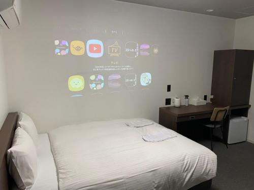 佐贺市TAPSTAY HOTEL - Vacation STAY 35238v的一间卧室配有一张床和一张带墙壁的书桌
