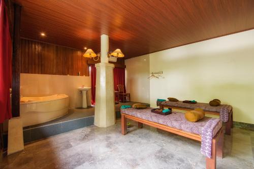 乌布Champlung Sari Villa & Spa Ubud的带浴缸、长凳和盥洗盆的浴室