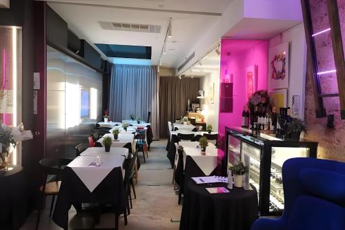 新加坡Hi Hotel Bugis的餐厅的一排餐桌,有粉红色的灯光