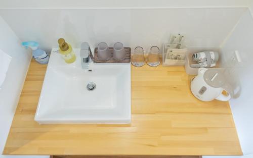 宫古岛BiBi Hotel 宮古空港前的铺有木地板,设有带白色水槽的浴室