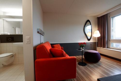 韦因费尔登Hotel Thurgauerhof Self-Check-in的一间带红色椅子的客厅和一间浴室
