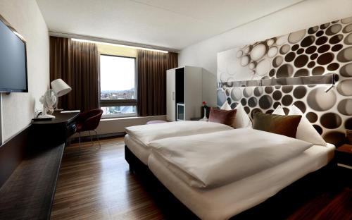 韦因费尔登Hotel Thurgauerhof Self-Check-in的酒店客房设有一张大床和一张书桌。
