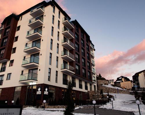 科帕奥尼克Harmonija Resort - Harmonia Palace的前面有雪的白色高楼