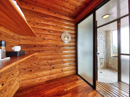 今归仁村长冈海滩度假村 的一间设有木墙和墙上时钟的房间