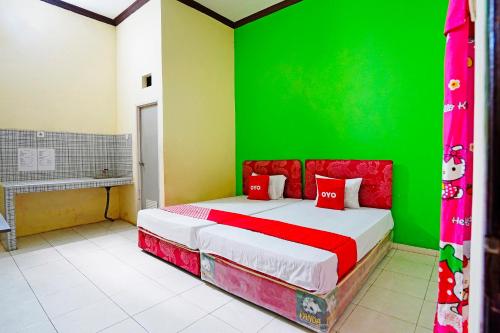 Tambak-kidulOYO 91583 D’cost Green Syariah的一间卧室设有绿色的墙壁和一张床