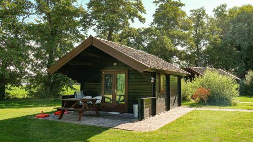 皮滕Blokhut的小屋,设有野餐桌,位于草地上