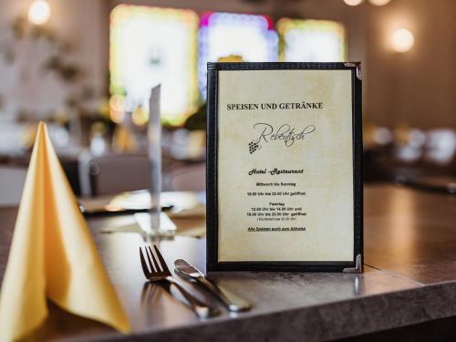 哈瑟尔费尔德REBENTISCH - HOTEL Ferienwohnungen Restaurant的桌子上带餐具的菜单