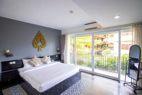 暹粒1 BR Serviced Apt In The Heart of Siem Reap的一间卧室设有一张床和一个大窗户