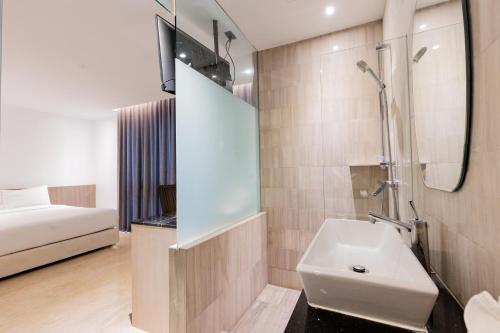 曼谷素可泰住鲁安吕迪旅馆的一间带水槽和淋浴的浴室以及一张床