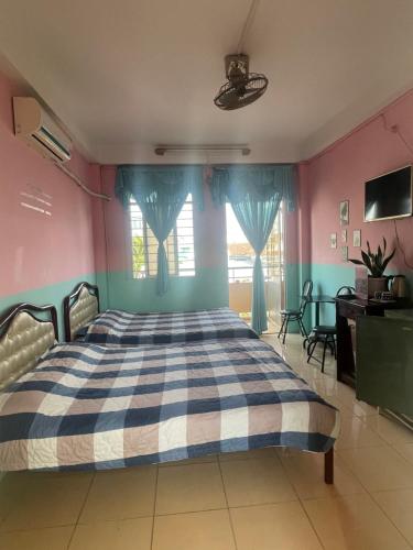 河仙Huỳnh Hương Guesthouse的一间卧室配有一张蓝色和粉红色的墙壁。