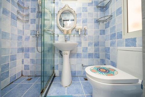上海Shanghai Hills & Well-time Memphis B&B的蓝色瓷砖浴室设有卫生间和镜子