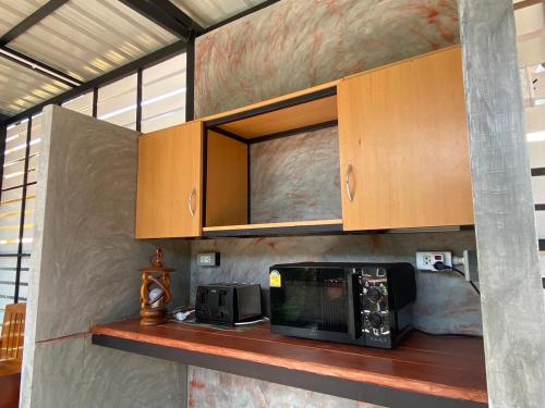 奈扬海滩桑塔里之家旅馆的厨房配有带微波炉和橱柜的台面