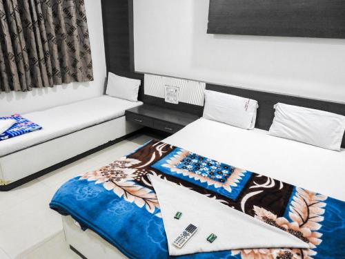 舍地Hotel Shree Sai Darshan的一间客房配有两张床和一张沙发