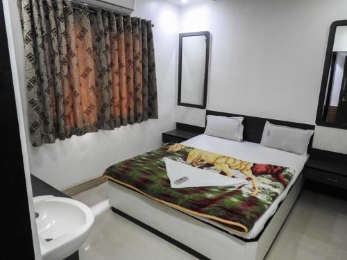 舍地Hotel Shree Sai Darshan的一间带床和水槽的小卧室