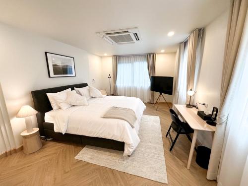 曼谷Upscale 3-bedroom 3-bathroom suite 1 min to BTS Prompong的一间卧室配有一张床、一张书桌和一台电视