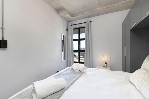 布鲁堡史特兰Manhattan on Coral 7的白色的卧室设有一张大床和一个窗户