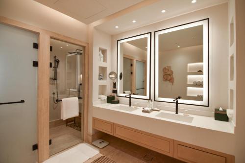 多哈Katara Hills Doha, Lxr Hotels & Resorts的一间带两个盥洗盆和大镜子的浴室