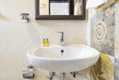 GoaAravind Residency Calangute的浴室设有白色水槽和镜子