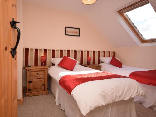 伍尔法迪斯沃西3 Bed in Woolsery LABBA的一间卧室设有两张床和窗户。