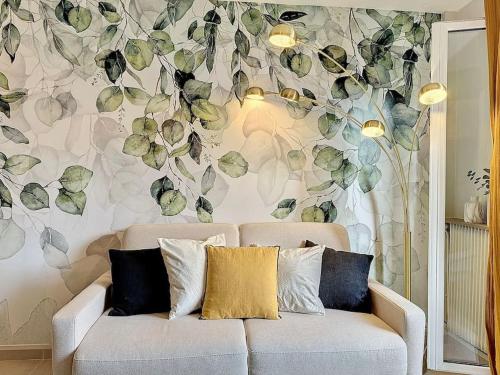 多维尔Le Longchamp的客厅的沙发,带有花卉墙