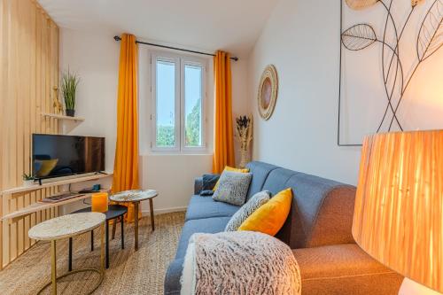 圣艾米隆LA MAISON DES VIGNES SAINT EMILION的客厅配有蓝色的沙发和电视
