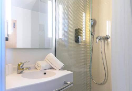 尼姆B&B HOTEL Nîmes Centre Arènes的一间带水槽和淋浴的浴室