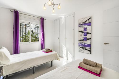 马贝拉Casa Stefania的紫色窗帘间内的两张床